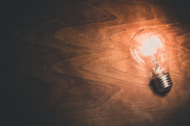 Innovationen Glühbirne auf Holzuntergrund