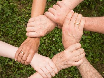 Menschen die sich an den Händen festhalten.